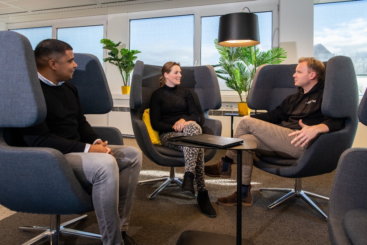 Drie collega's op ruime stoelen